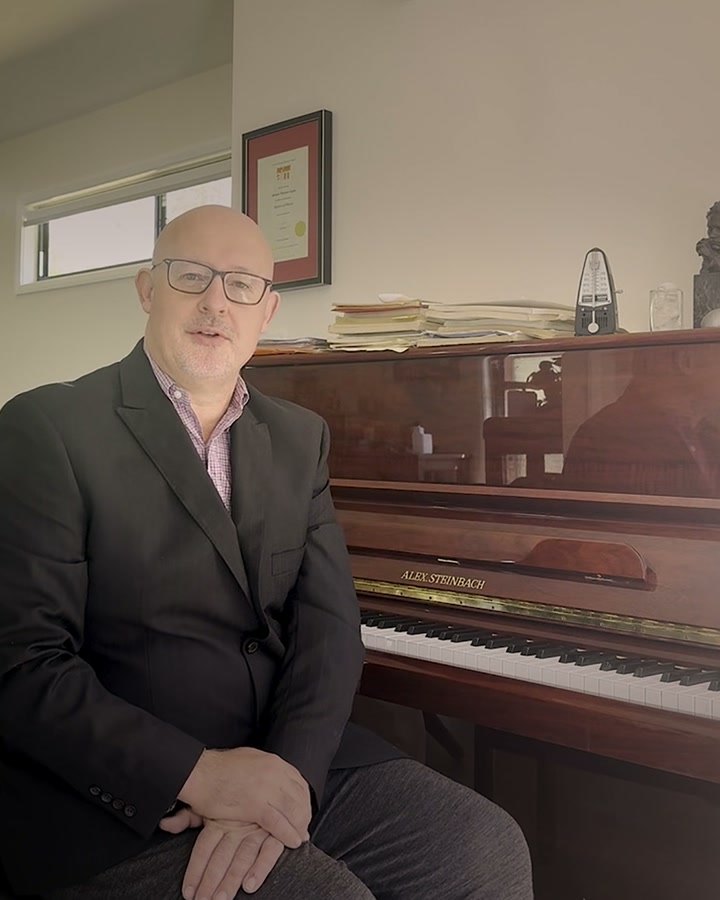 William Coyle seated at an upright piano